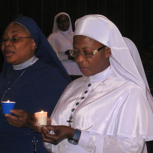 Nun praying with candle